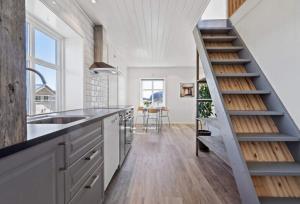 una cocina con fregadero y una escalera. en Ragnahuset - Koselig minihus i fiskevær en Skaftneset