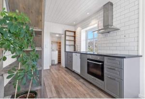 a kitchen with a sink and a stove top oven at Ragnahuset - Koselig minihus i fiskevær in Skaftneset