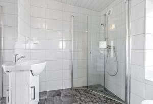 a white bathroom with a shower and a sink at Ragnahuset - Koselig minihus i fiskevær in Skaftneset