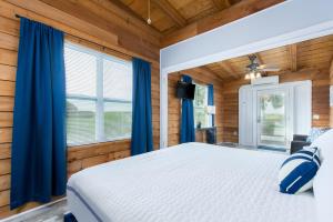 a bedroom with a white bed and blue curtains at Darien Dockside Inn in Darien