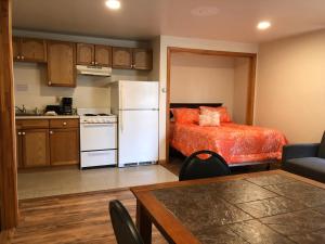 a kitchen and a living room with a bed and a white refrigerator at Marcotte Motor Court in Old Orchard Beach
