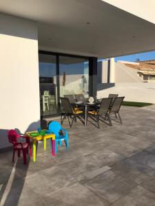 d'une terrasse avec des chaises et une table avec des chaises. dans l'établissement Villa do Barrudo, à Vila do Bispo