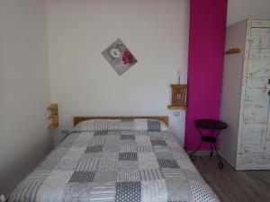 a bedroom with a bed and a pink wall at AltaValle Holiday Home, monolocale Pink e bilocale Lime in Chiesa in Valmalenco