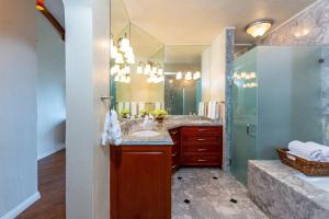 a bathroom with a sink and a shower with a mirror at Spacious Open-Concept Condo with Stylish Design, Direct Beach Access & Resort-Style Amenities in Playa Flamingo +41 photos