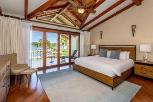 a bedroom with a bed and a view of the ocean at Spacious Open-Concept Condo with Stylish Design, Direct Beach Access & Resort-Style Amenities in Playa Flamingo