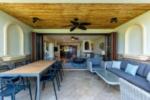sala de estar con mesa, sillas y techo en Stylish Split-Level Condo with a Shaded Terrace, Direct Beach Access, and Resort-Style Community Amenities, en Playa Flamingo