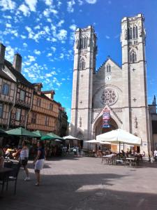 eine Kirche mit einem hohen Turm mit einer Uhr in der Unterkunft CHAMBRE CHEZ L HABITANT in Chalon-sur-Saône