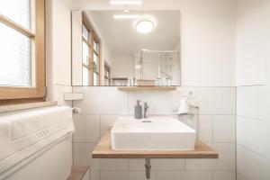 a white bathroom with a sink and a mirror at Hotel Am Markt in Munich