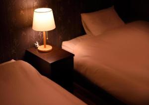 a lamp on a night stand next to a bed at Dai Onsen Matsudaya Ryokan - Vacation STAY 67479 in Hanamaki