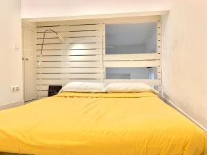 a large yellow bed in a room with a window at Apartamentos Puerta del Sol-Rastro in Madrid
