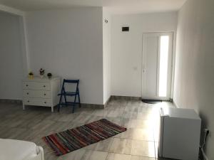 a white room with a table and a chair and a door at Casa Dada in 2 Mai