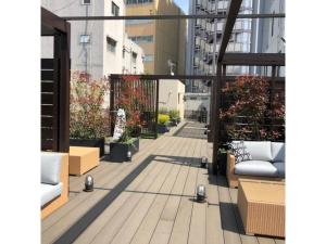 東京にあるAct Hotel Roppongi - Vacation STAY 85367のベンチと植物のあるバルコニーの景色を望めます。