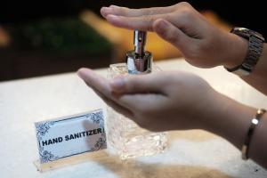 a person is holding a bottle of hand sanitizer at Lembongan Mantra Huts - CHSE Certified in Nusa Lembongan