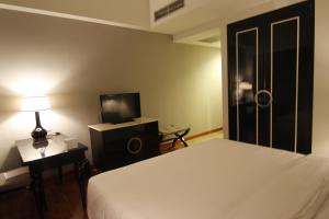 1 dormitorio con 1 cama, TV y lámpara en Hotel Diradja, en Yakarta