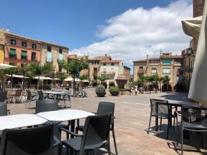 an outdoor patio with tables and chairs and buildings at EVA & TRAVEL - Triplex La Cavallada in Prades