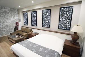 a bedroom with a bed and a couch and windows at Lex Suwa (Adult Only) in Suwa