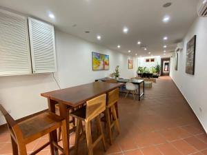 a dining room with a wooden table and chairs at Heeren Straits Hotel in Malacca