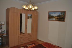 Habitación con armario de madera y una foto en la pared. en Anett Apartman, en Siófok