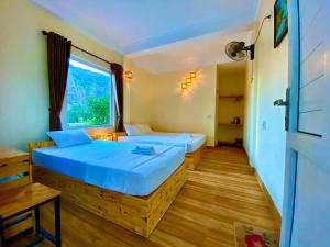een kamer met 2 bedden en een raam bij Ha Lan Homestay in Ninh Binh