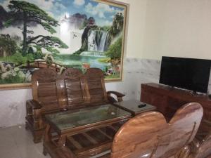 a living room with a television and a painting on the wall at Nhà Nghỉ An Phát in Phú Hiệp