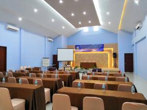 a room with brown tables and chairs and a screen at Grand Mahoni Hotel in Banda Aceh