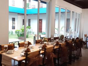 un lungo tavolo in una stanza con ampie finestre di Grand Mahoni Hotel a Banda Aceh