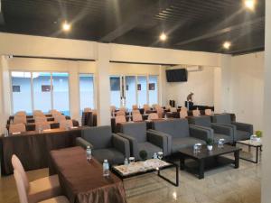 a large room with couches and chairs and a podium at Grand Mahoni Hotel in Banda Aceh