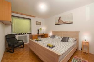 a bedroom with a bed and a chair and a window at Apartments Rikli Bled in Bled