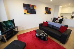 a living room with a black couch and a red rug at Melbourne Knox Central Apartment Hotel Official in Wantirna +46 photos