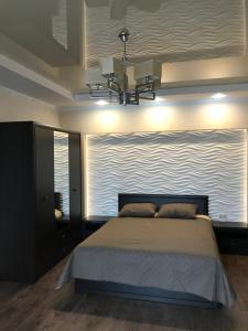 a bedroom with a large bed and a large window at Затишні сучасні апартаменти в елітному ЖК Версаль in Truskavets