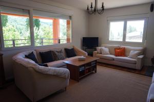 Sala de estar con 2 sofás y mesa de centro en casa sierra avellaneda avila, en Avellaneda