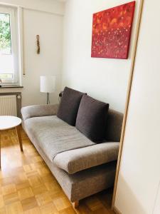 eine Couch in einem Wohnzimmer unter einem Gemälde in der Unterkunft FeWo Im Sonnenbuhl in Konstanz