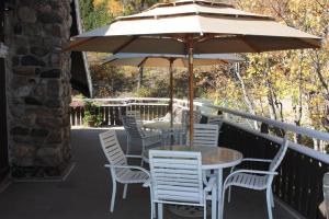 a table and chairs with an umbrella on a balcony at Northland Lodge in Waterton Park