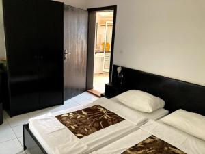 una camera con letto e testiera nera di Guest house Dragović a Sveti Stefan