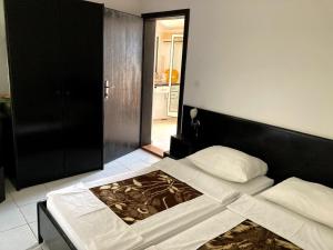 a bedroom with a bed with a black headboard at Guest house Dragović in Sveti Stefan