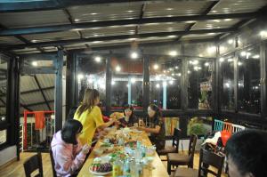 un grupo de personas sentadas alrededor de una mesa larga en Anh Trang Homestay en Dalat