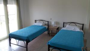 two beds sitting in a room with a window at Kokkos Brothers in Kallithea Halkidikis