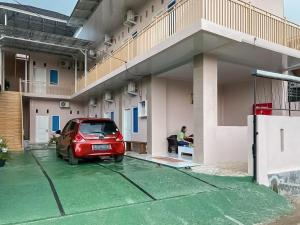 a car parked in front of a house at RedDoorz Syariah near PKOR Lampung in Bandar Lampung