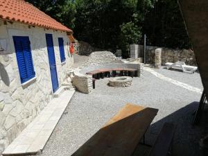 a stone building with a fire pit in a courtyard at Maleluni in Malinska