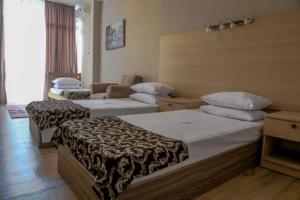 a hotel room with two beds and a couch at Hotel Borjomi Aisi in Borjomi