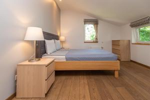 a bedroom with a bed and a lamp on a wooden floor at S11 in Palanga