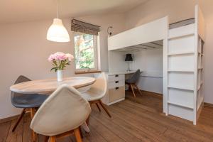 una sala da pranzo con tavolo, sedie e letto a castello di S11 a Palanga