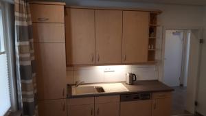 a kitchen with wooden cabinets and a sink at 4-Sterne Ferienwohnung Carbach -Perfekt für Radfahrer- in Boppard +11 photos