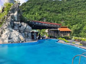 ein Zug, der eine Brücke über einen Pool in einem Resort überquert in der Unterkunft Cat Ba Mountain View in Cát Bà