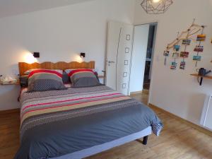 Un dormitorio con una cama grande y una cruz en la pared en Les Terrasses, en Saint-Paul-en-Pareds