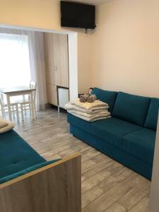 a living room with a blue couch and a table at Jantarowy Sen in Jantar