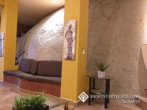 特卡特的住宿－Short Stay Tecate Hotel Boutique，黄色墙壁的房间里一张沙发