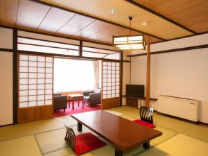 Zimmer mit einem Tisch, Stühlen und einem Fenster in der Unterkunft Ichiryukaku Honkan in Nikko