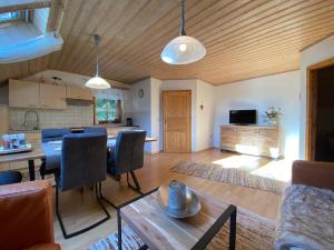 ein Wohnzimmer mit einem Esstisch und einer Küche in der Unterkunft Ferienhäuser Geiersberg in Hauzenberg