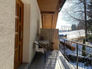 uma varanda de uma casa com uma mesa e uma cerca em Ferienhäuser Geiersberg em Hauzenberg